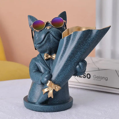 Blue cat figurine with sunglasses and a gold bow tie on a white surface.
