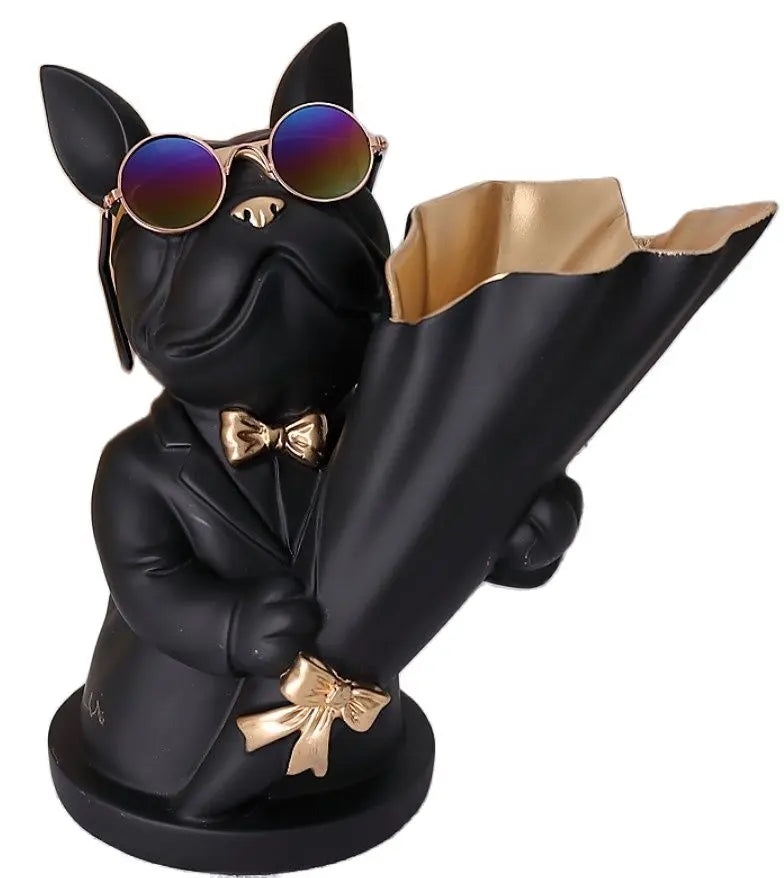 Black dog figurine wearing sunglasses and a suit with a gold bow tie, holding a gold umbrella.