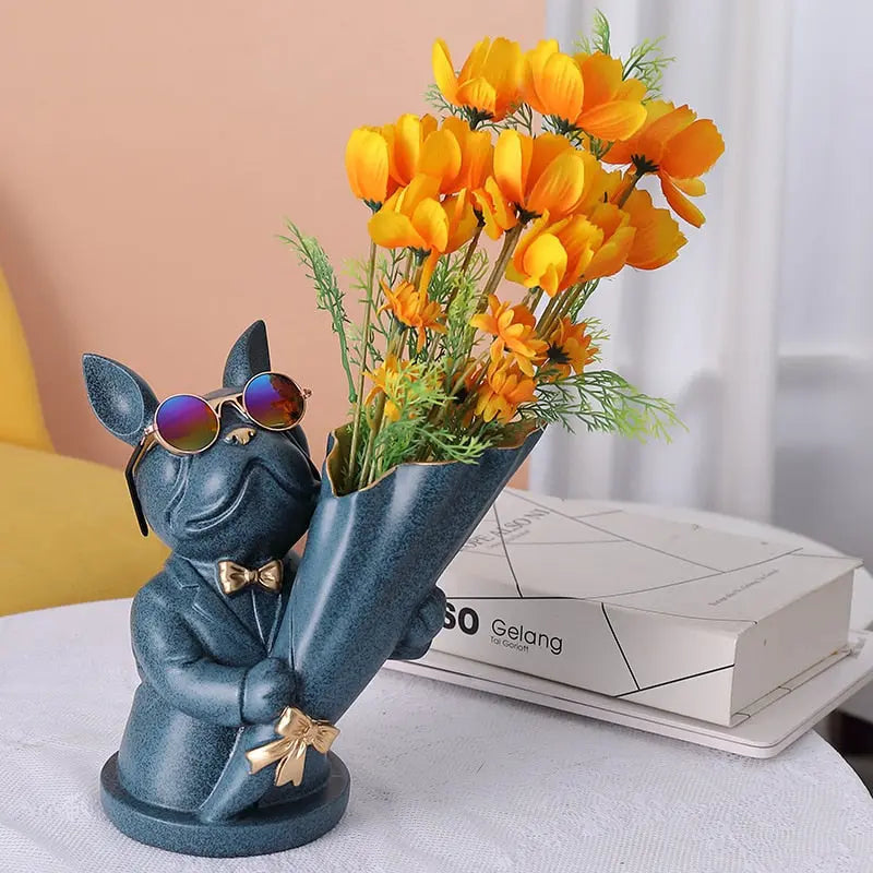 Decorative vase shaped like a dog holding sunglasses and flowers on a table.