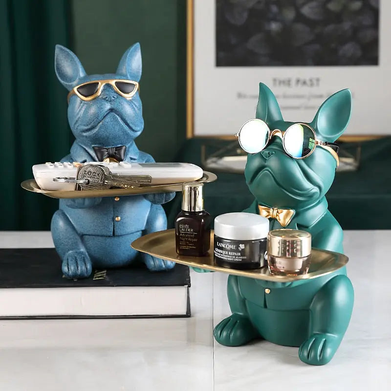 Two decorative dog figurines with trays holding items on a surface.