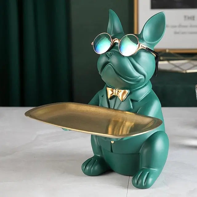 Green dog figurine with sunglasses and a gold bow tie holding a gold tray.