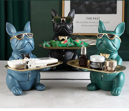 Three decorative dog figurines with sunglasses holding various items on a surface.