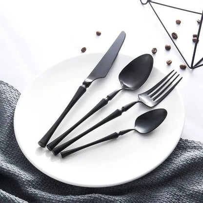 Black cutlery set on a white plate with a geometric black design in the background.