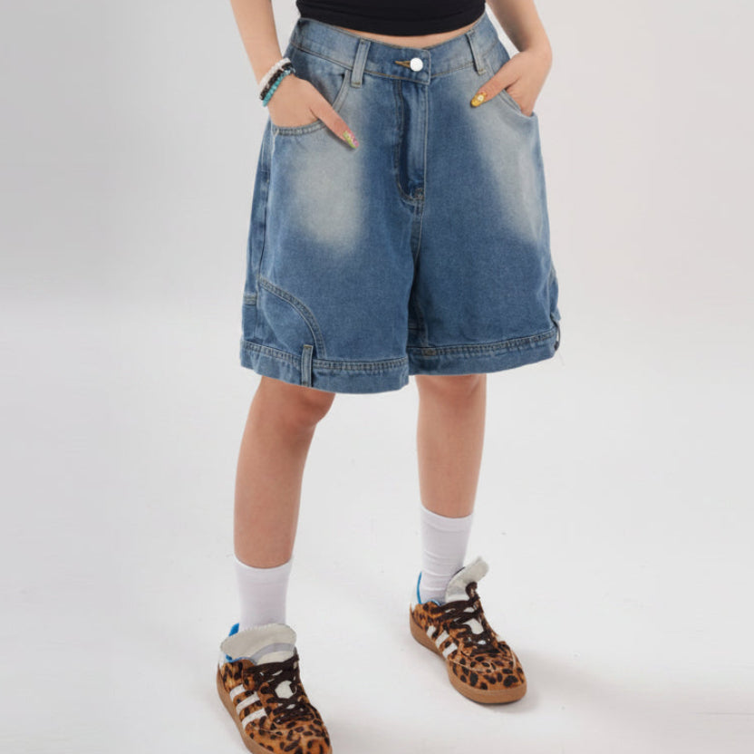 Person wearing blue denim shorts on a white background