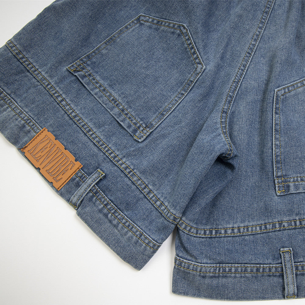 Close-up of a blue denim jacket with a brown patch on a white background