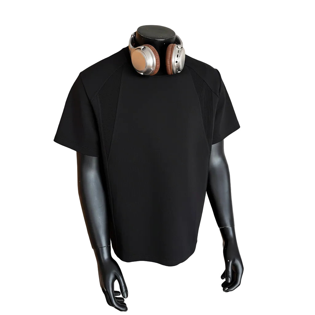 Black shirt on a mannequin with a gold and black helmet against a beige wall.