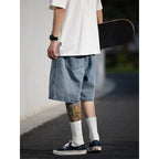 Person wearing a white t-shirt, blue denim shorts, and white socks, holding a skateboard.