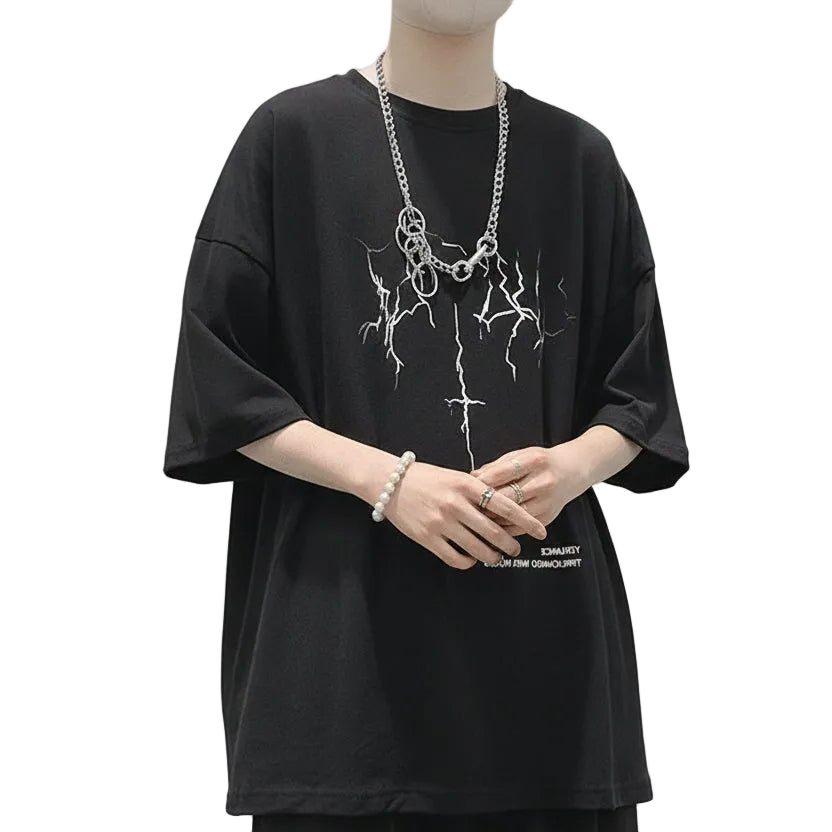 Person wearing a black oversized t-shirt with white text and graphics on a plain background