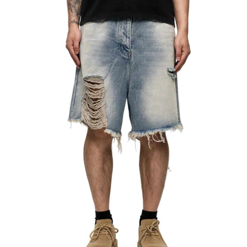 Person wearing distressed denim shorts on a white background