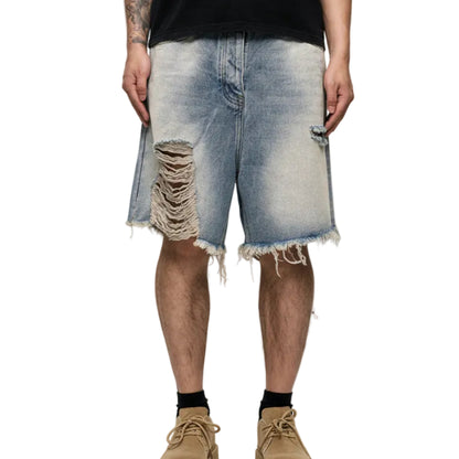 Person wearing distressed denim shorts on a white background