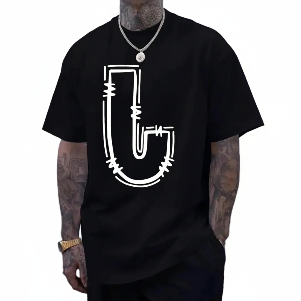 Person wearing a black t-shirt with a white graphic design against a gray wall.