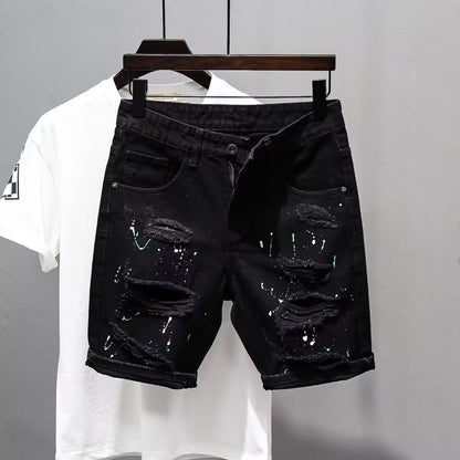 Black distressed denim shorts on a hanger with a white t-shirt in the background.