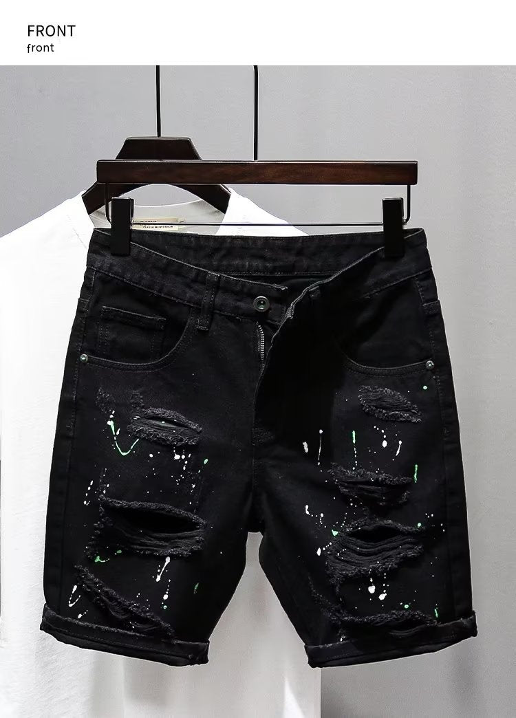 Black distressed denim shorts on a hanger against a white background
