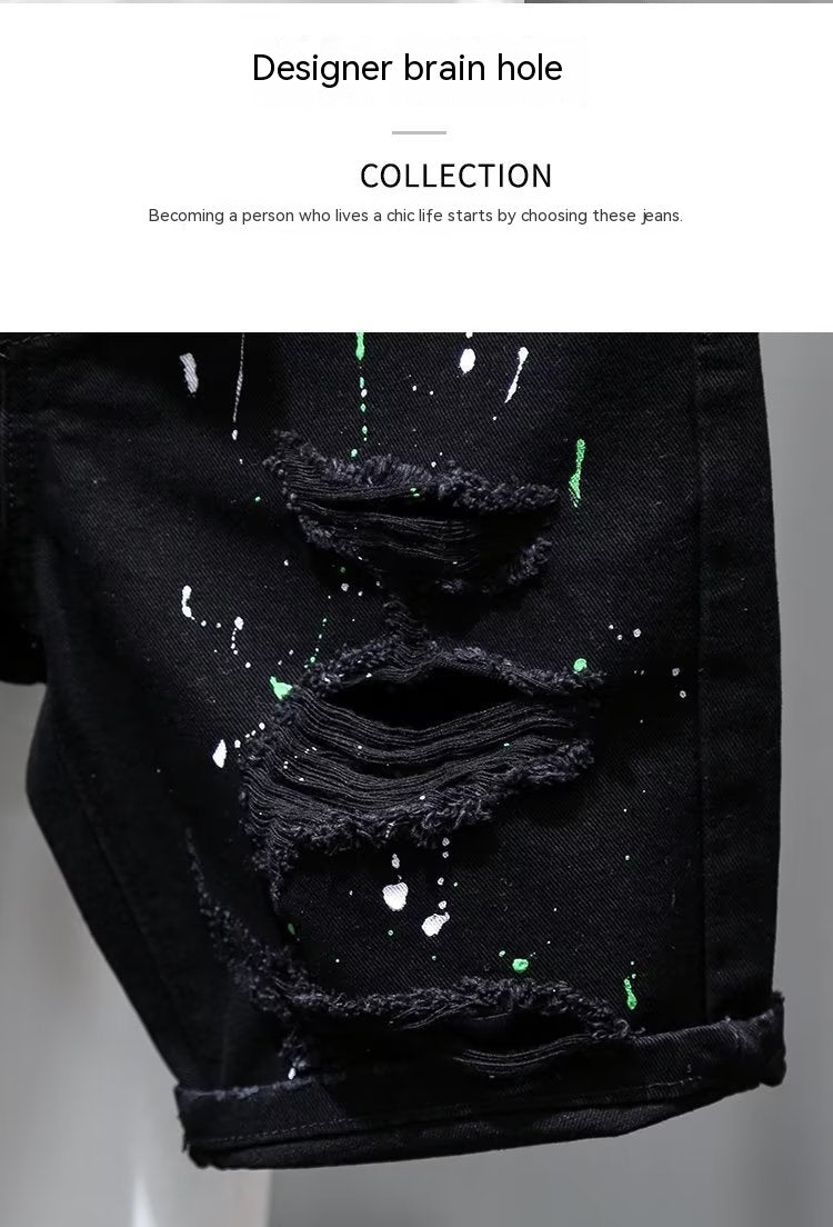 Black distressed denim jeans with glowing paint splashes on a gray background