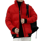 Person wearing a red puffer jacket with a black backpack indoors.