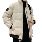Person wearing a red puffer jacket with a black backpack indoors.