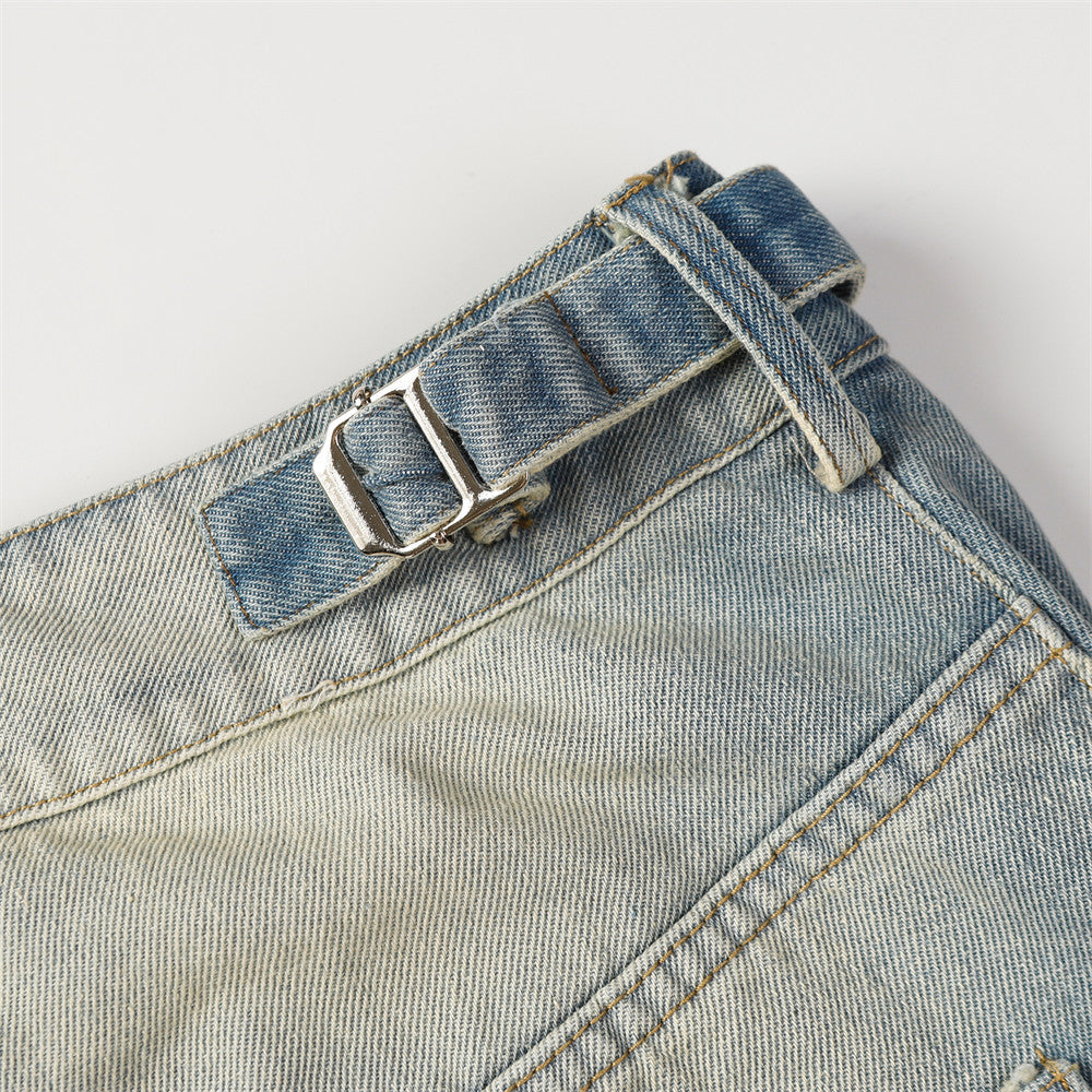 Close-up of a blue denim belt with a buckle on a light gray background