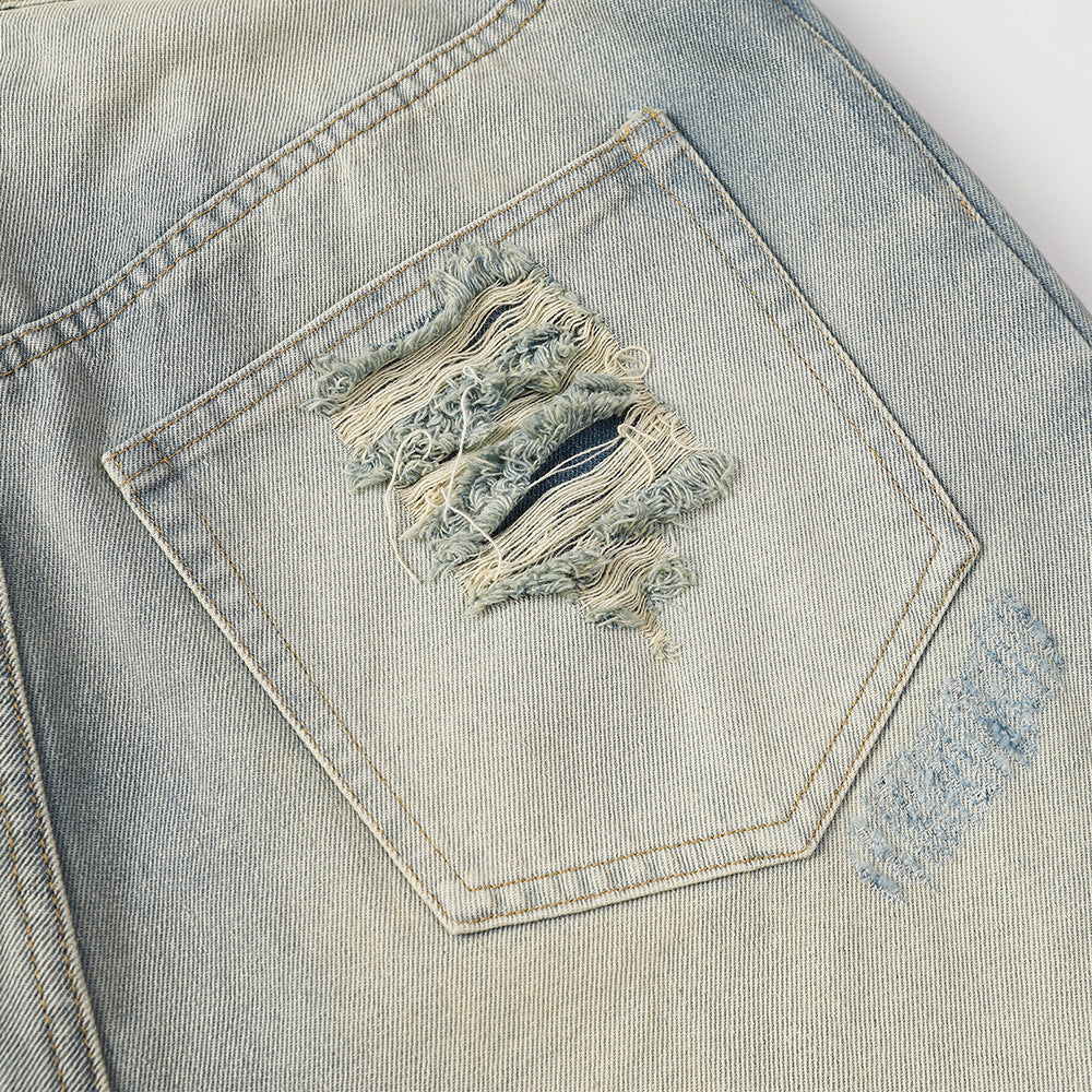Close-up of a distressed pocket on a denim jacket.
