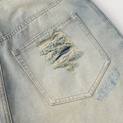 Close-up of a distressed pocket on a denim jacket.